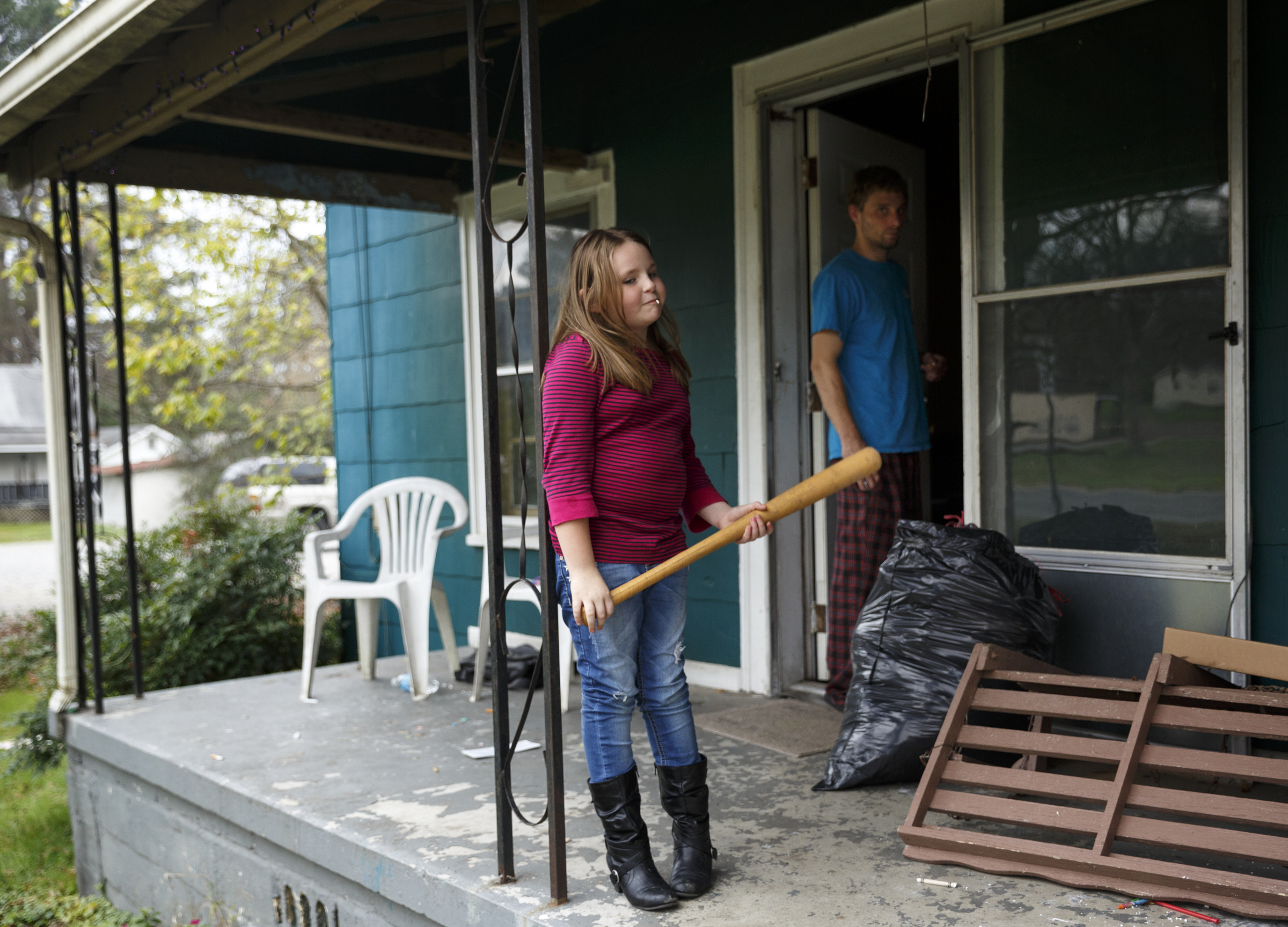 Zoey Stackpole, left, plays on the porch with her father Lee at their home on South Chattanooga Street on Tuesday, Nov. 17, 2015, three days after a fire destroyed much of the adjacent Barwick Mills building in Lafayette, Ga. The EPA has been taking air samples to assess the impact of the fire.