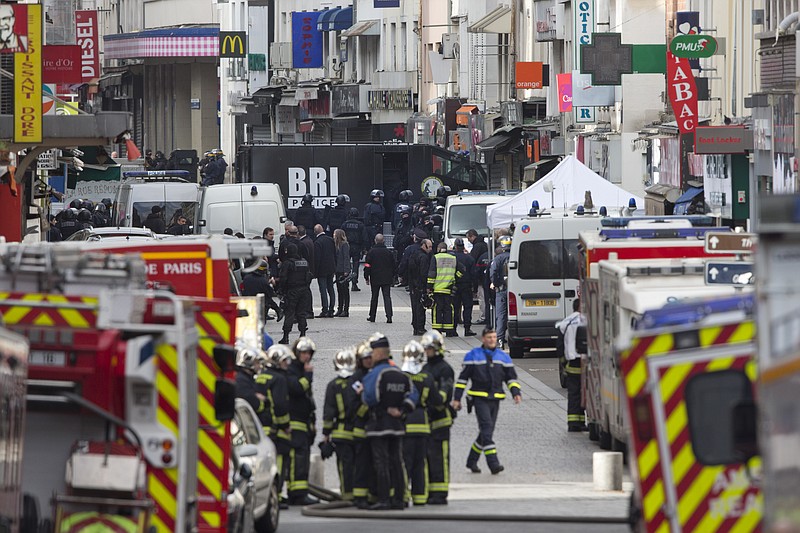 
              Police officers of the research and intervention brigade (BRI) walk to their truck in Saint-Denis, near Paris, Wednesday, Nov. 18, 2015. A woman wearing an explosive suicide vest blew herself up Wednesday as heavily armed police tried to storm a suburban Paris apartment where the suspected mastermind of last week's attacks was believed to be holed up, police said. (AP Photo/Peter Dejong)
            
