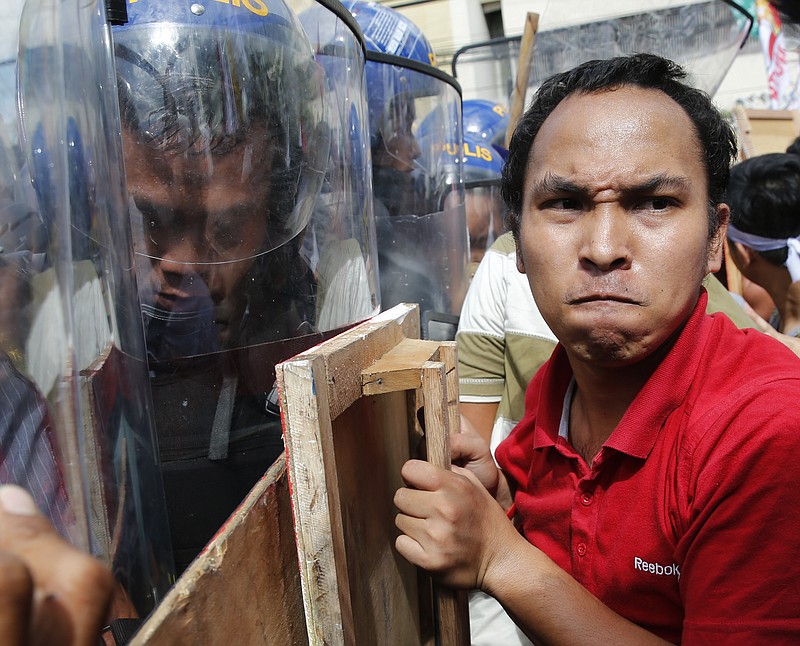 
              Student activists clash with police near the venue hosting the Asia-Pacific Economic Cooperation (APEC) summit in Manila, Philippines, Thursday, Nov. 19, 2015. Asia-Pacific leaders called Thursday for increased international cooperation in the fight against terrorism as they held annual talks overshadowed by the Paris attacks. (AP Photo/Wally Santana)
            