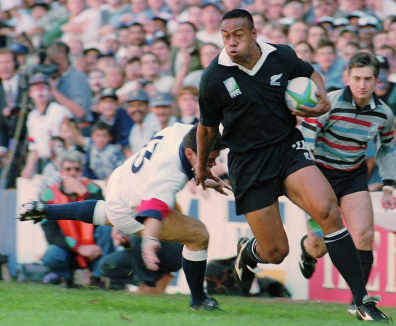 
              In this June 18, 1995 file photo, New Zealand All Blacks winger Jonah Lomu runs around England's Will Carling on his way to score the opening try in the Rugby World Cup semifinal at Newlands in Cape Town, South Africa. Lomu, whose power and pace revolutionized rugby and whose humility and grace won millions of fans, died early Wednesday, Nov. 18, 2015, New Zealand Rugby said. He was 40. (AP Photo/Ross Setford,File)
            