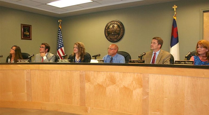 Members of the Unicoi County Board of Education pictured here at their September meeting with the Christian flag, Tennessee state seal and U.S. flag displayed behind their seats at the front of the meeting room. (Sue Guinn Legg/Johnson City Press)