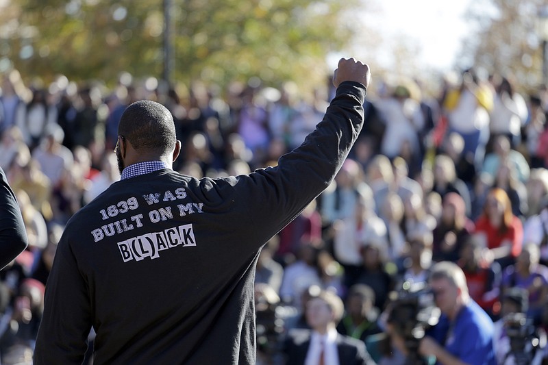 In this Nov. 9, 2015, file photo, a member of the black student protest group Concerned Student 1950 gestures while addressing a crowd following the announcement that University of Missouri System President Tim Wolfe would resign, at the university in Columbia, Mo.