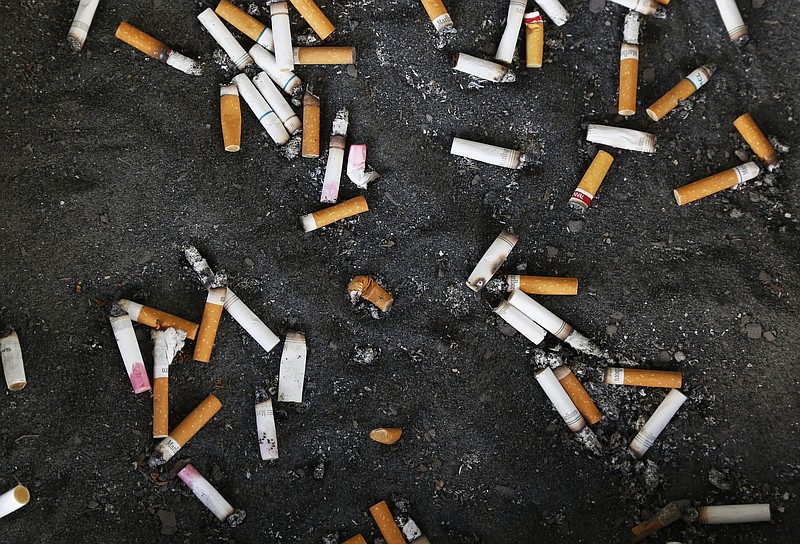 FILE - This Thursday, Sept. 17, 2015 file photo shows an ashtray with cigarette butts outside the Oklahoma County Courthouse in Oklahoma City. Researchers found that smokers who switched to special low-nicotine ones wound up smoking less and were more likely to try to quit, according to a new study published in the New England Journal of Medicine on Wednesday, Sept. 30, 2015. (AP Photo/Sue Ogrocki)