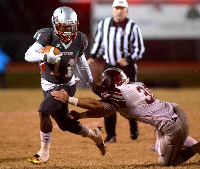 Ooltewah's Rashun Freeman (11) escapes the tackle of Oak Ridge's Adam Manookian (35).  The Oak Ridge Wildcats visited the Ooltewah Owls in the second round of the TSSAA 5A football playoffs on Friday 13, 2015.