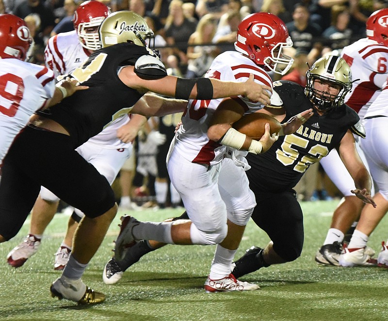 Dalton's Jase Chastain (10) tries to escape the reach of Calhoun's Landon Rice, left, and Blaine Anderson (52) in second quarter action at Calhoun.