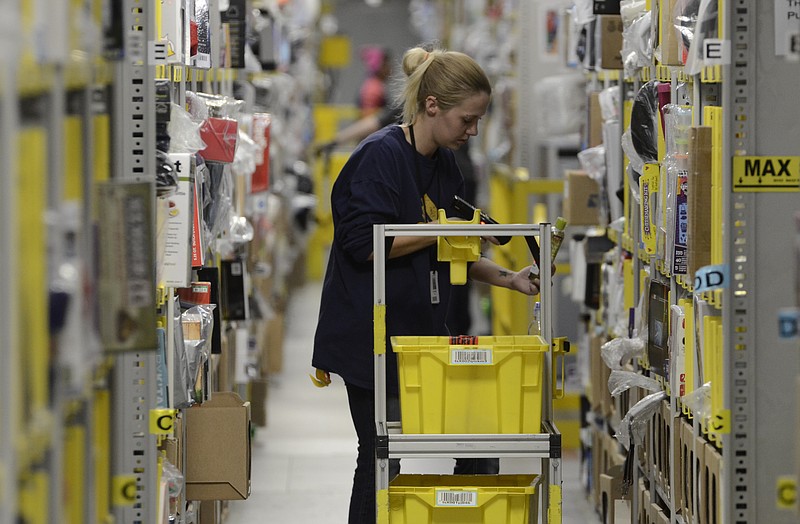 Staff File Photo / Heather Vance picks items from a row of shelves to fill orders on Cyber Monday of last year at the Amazon fulfillment center in the Enterprise South Industrial Park in Chattanooga.