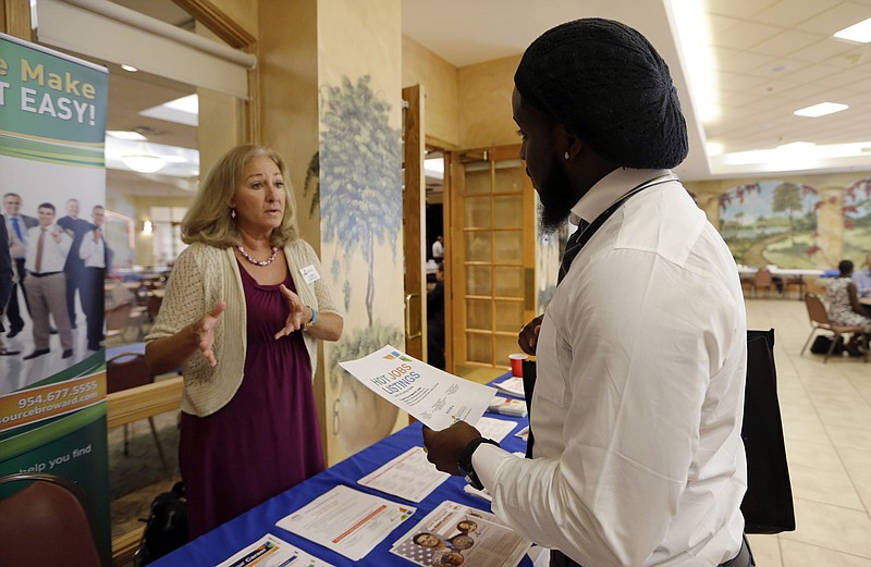 
              In this Oct. 6, 2015, photo, military veteran Mark Cannon, of Miami, right, talks with Cynthia Carcillo, a veterans outreach representative for Career Source Broward, about employment opportunities at a job fair for veterans, in Pembroke Pines, Fla. The Labor Department reported Thursday, Nov. 19, 2015, that fewer Americans sought unemployment aid a week earlier, fresh evidence that companies are confident enough in the economy to hold onto their workers. (AP Photo/Lynne Sladky)
            