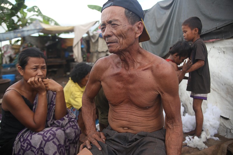 
              In this Monday, Nov. 16, 2015 photo, Winfredo Sumaya, 60-years-old sits in front of his house in the slum "Smokey Mountain" in Manila, Philippines. Just a few miles from the gleaming venue hosting President Barack Obama and other world leaders sits Manila's slum of slums on a mountain of trash, a potent reminder of the dilemmas that haunt the free trade and globalization agenda promoted by groups like the Asia-Pacific Economic Cooperation forum. (AP Photo/Lino Escandor II)
            