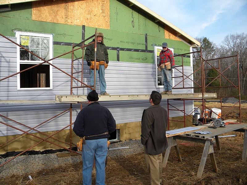 Terry McCoy and Don Kinnerson, from left on scaffold, talk with 
Jerry Franitza, Habitat for Humanity of Cleveland construction 
supervisor, in this file photo.