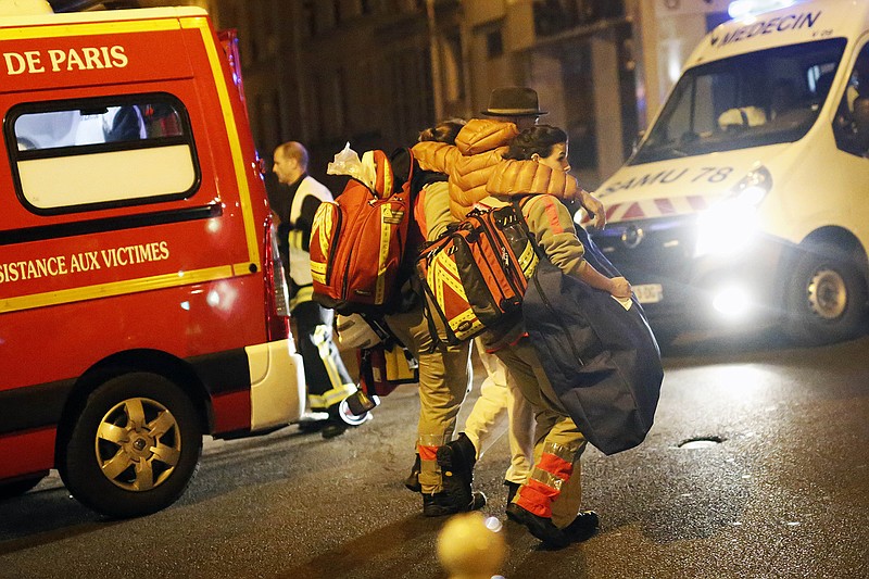 A victim is evacuated after a shooting, near the Bataclan theater in Paris, Friday Nov. 13, 2015. Well over 100 people were killed  in a series of shooting and explosions explosions. French President Francois Hollande declared a state of emergency and announced that he was closing the country's borders. (AP Photo/Jerome Delay)