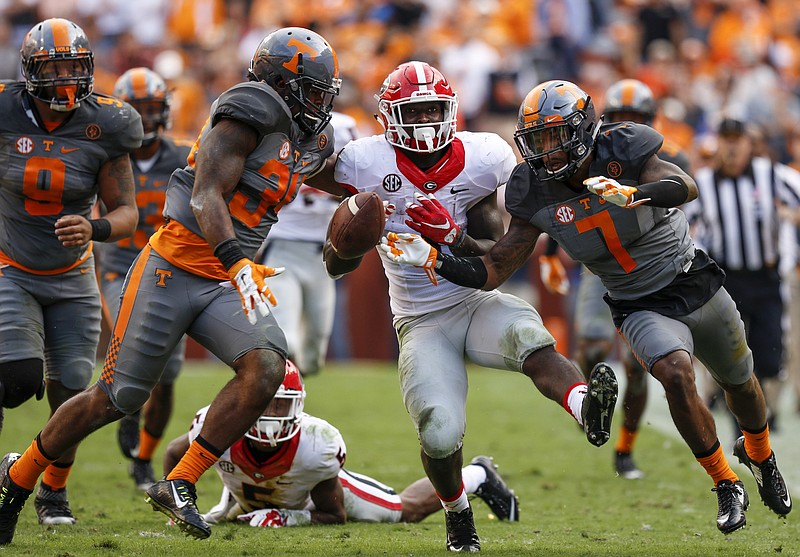 Georgia tailback Sony Michel, center, fumbles the ball out of bounds after a long run while surrounded by Tennessee defenders Cameron Sutton, right, and Darrin Kirkland Jr.