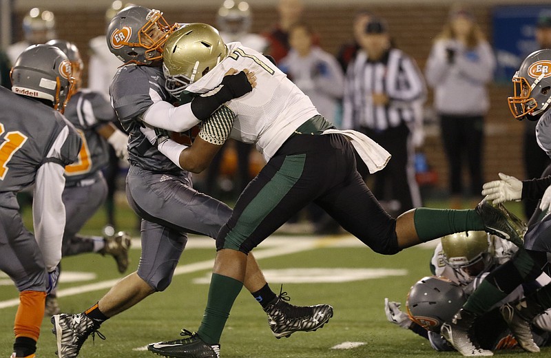 *Staff Photo by Dan Henry / The Chattanooga Times Free Press- 11/20/15. Notre Dame's Patrick Johnson (7) knocks East Ridge's Kentrell Harris 23) out of his way to gain first down yardage during Friday's quarterfinal playoff game on November 20, 2015. 