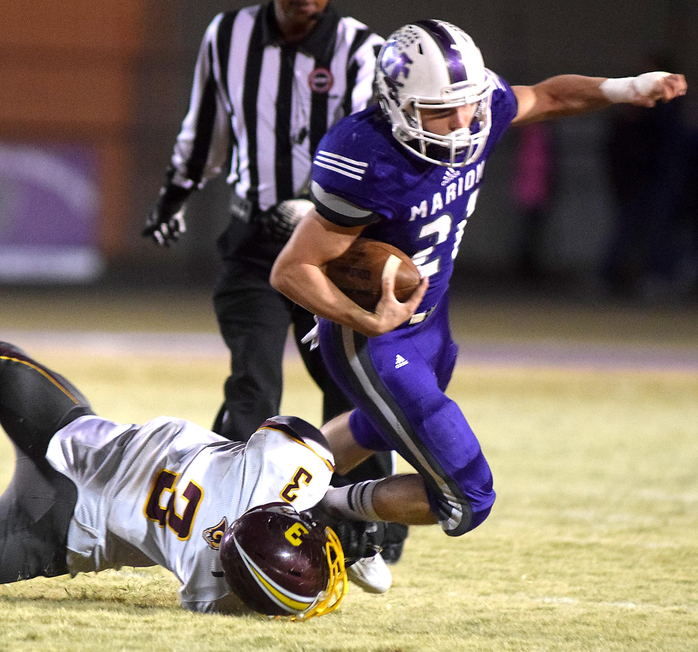 Marion County's Josh Henderson (21) is brought down by Tyner's Jadarius Paris (3). The Tyner Rams visited the Marion County Warriors in a quarterfinal game in the TSSAA State Football Playoffs on Friday November 20, 2015.