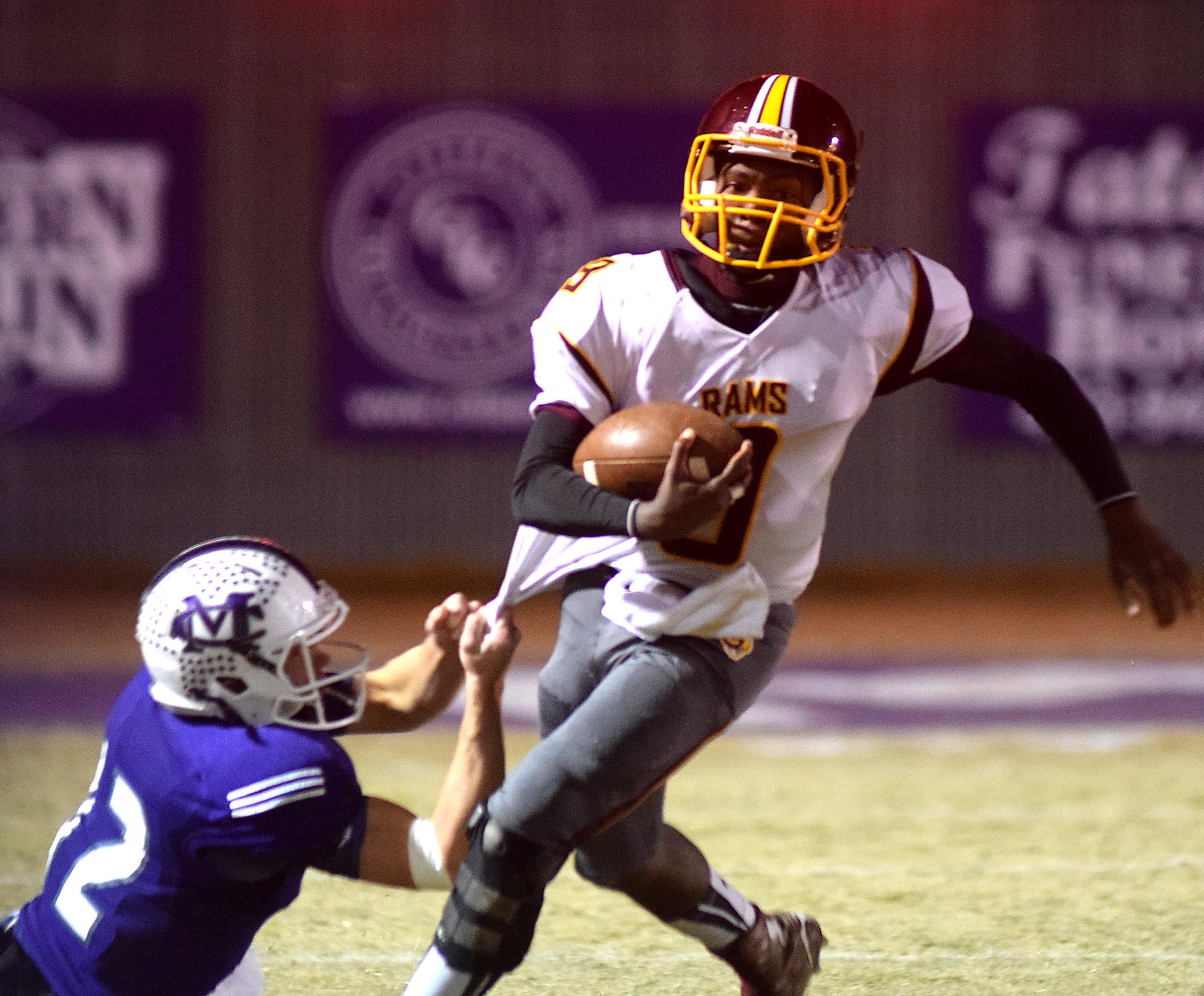 Tyner's Emmanuel Moss (9) picks up yardage as Marion County's Bryce Massengale (12) holds on. The Tyner Rams visited the Marion County Warriors in a quarterfinal game in the TSSAA State Football Playoffs on Friday November 20, 2015.