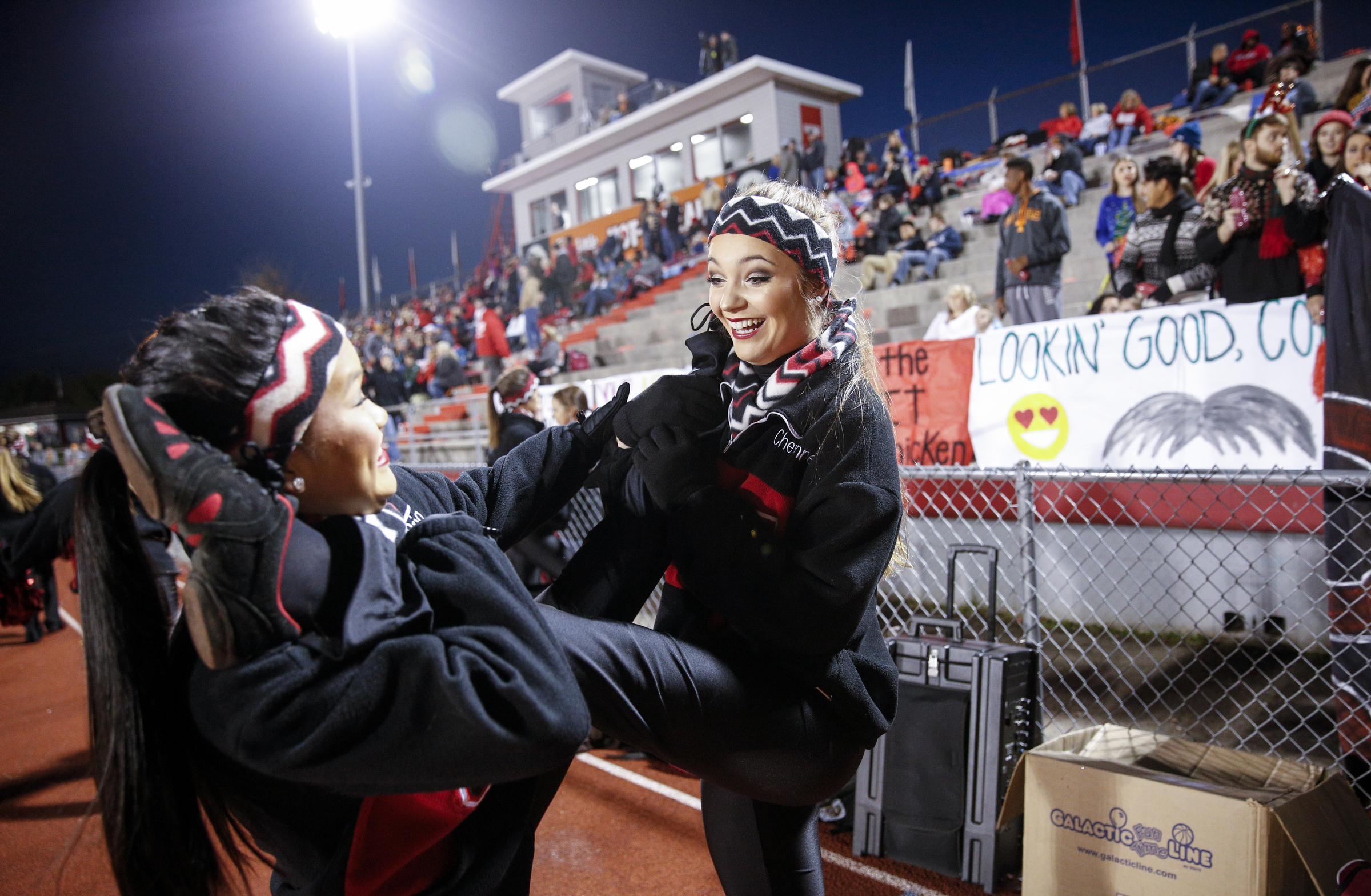Ooltewah High School dance team members Bria Miller, left, and Cheyenne Johnson help each other stretch before their TSSAA prep football playoff football game against Rhea County at Ooltewah High School on Friday, Nov. 20, 2015, in Ooltewah, Tenn.