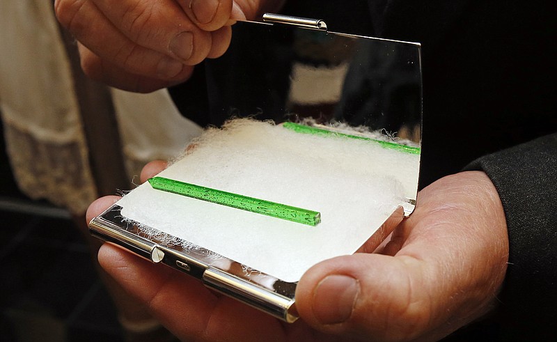 
              Rep. Bo Eaton, D-Taylorsville, displays the card case that contained the winning green straw chosen during a blind lot pull between himself and Republican challenger Mark Tullos, Friday, Nov. 20, 2015, in the governor's office in Jackson, Miss.  Eaton picked the one with the longer, 3-inch green straw, giving him the victory and blocking the GOP from having a supermajority in the House. The pair were deadlocked following the Nov. 3 election.  (AP Photo/Rogelio V. Solis)
            