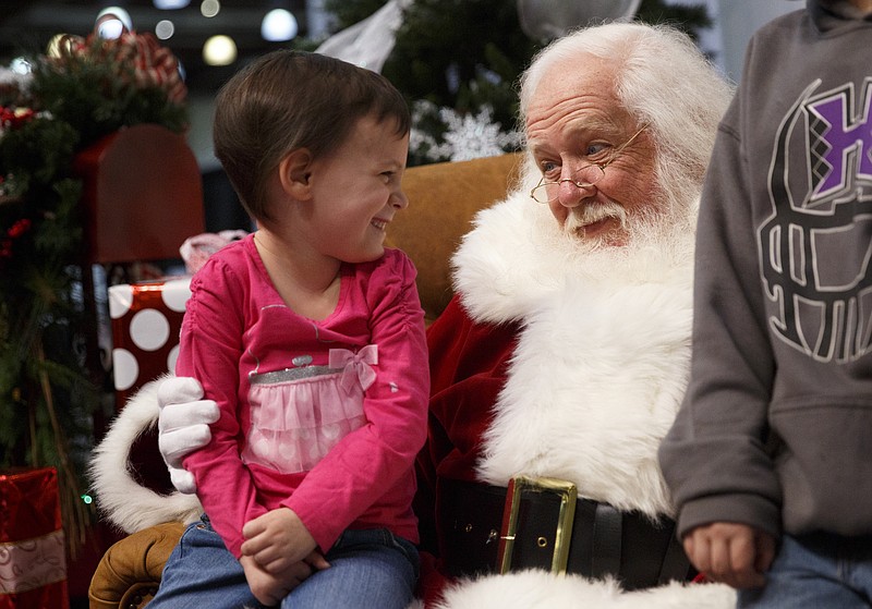 Autumn Harper, left, tells Santa what she wants for Christmas during the HoHo Expo at the Chattanooga Convention Center on Saturday, Nov. 21, 2015, in Chattanooga, Tenn. The expo features holiday and craft vendors and the chance to meet Santa.