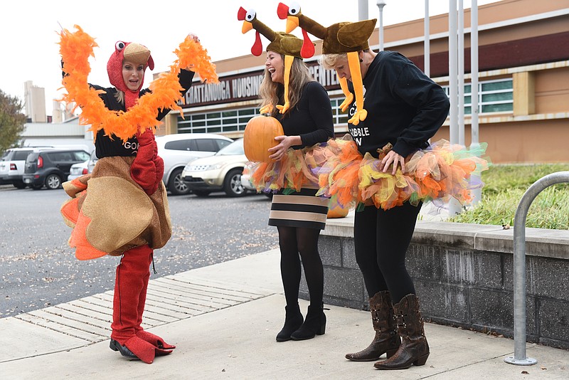 Theresa Biggs, left, Housing Navigator for the Chattanooga Housing Authority, wears her annual turkey suit to promote the Grateful Gobbler walk as Katie Morgan, center, and Betsy McCright join in the fun to raise funds for the homeless family shelter.