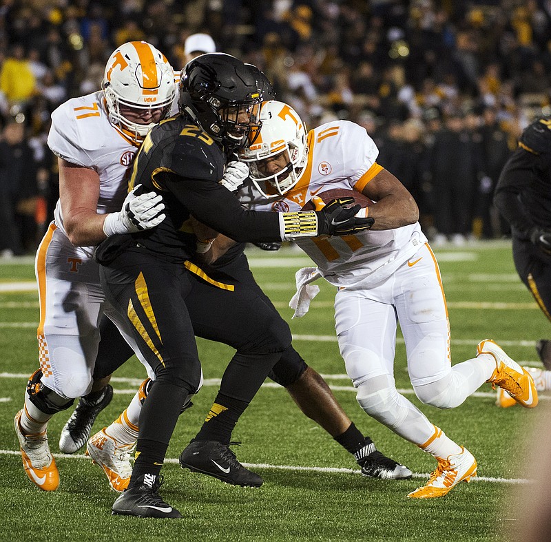 Tennessee quarterback Joshua Dobbs, right, pushes past Missouri's Donavin Newsom center, as Dylan Wiesman, left, blocks as Dobbs scores a touchdown during the first half of an NCAA college football game Saturday, Nov. 21, 2015, in Columbia, Mo. (AP Photo/L.G. Patterson)