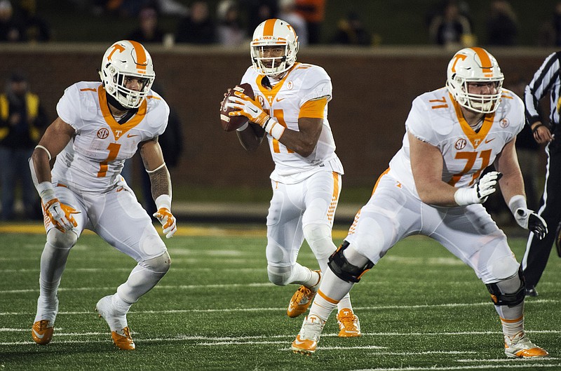 Tennessee quarterback Joshua Dobbs, center, throws a pass between teammates  Jalen Hurd, left, and Dylan Wiesman, right, during the first half of an NCAA college football game against Missouri, Saturday, Nov. 21, 2015, in Columbia, Mo. (AP Photo/L.G. Patterson)
