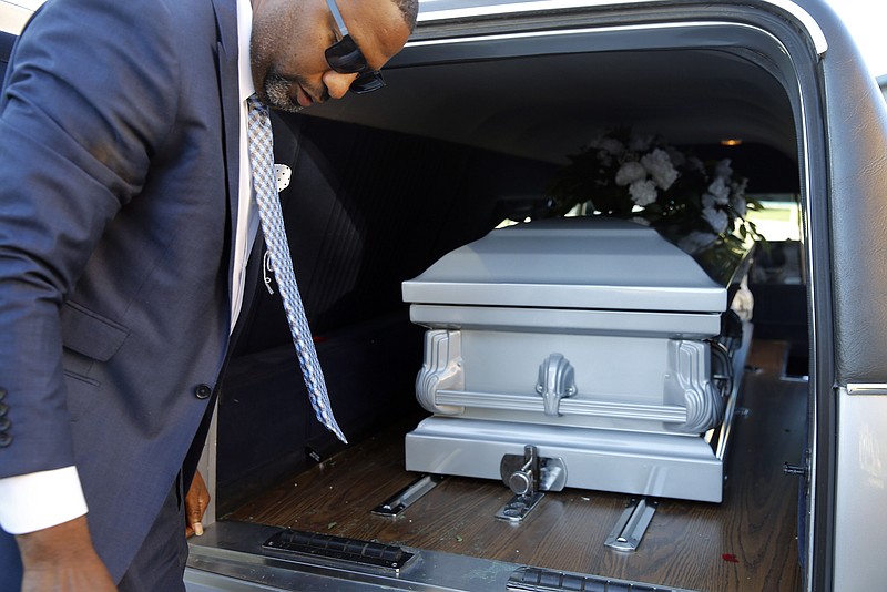 
              In this Oct. 16, 2015 picture, funeral director John Williams turns away after placing a casket containing the remains of a man who died of natural causes in a hearse in Baltimore. Coming off of the most violent year in the city's recent history, Williams has buried more bodies -- many of them young black men, many gunned down in the city’s west side -- than ever before. In a normal month, he might do three funerals. This past summer, he buried two people a week. Some died naturally, of illness or old age. Most showed up pierced by knives or bullets. (AP Photo/Patrick Semansky)
            