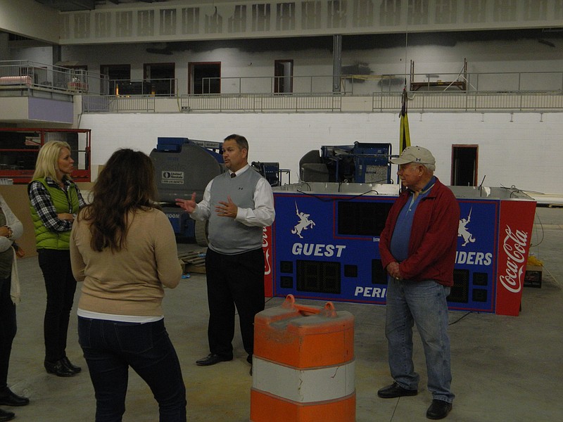 Dr. Martin Ringstaff, director of Cleveland City Schools, center, discusses the installation of Raider Arena's mid-court scoreboard with, from left, parent advisory council members Gina Allison and Holli Collins and city school board member George Meacham. Construction of the high school's new gymnasium is expected to be completed by early March.