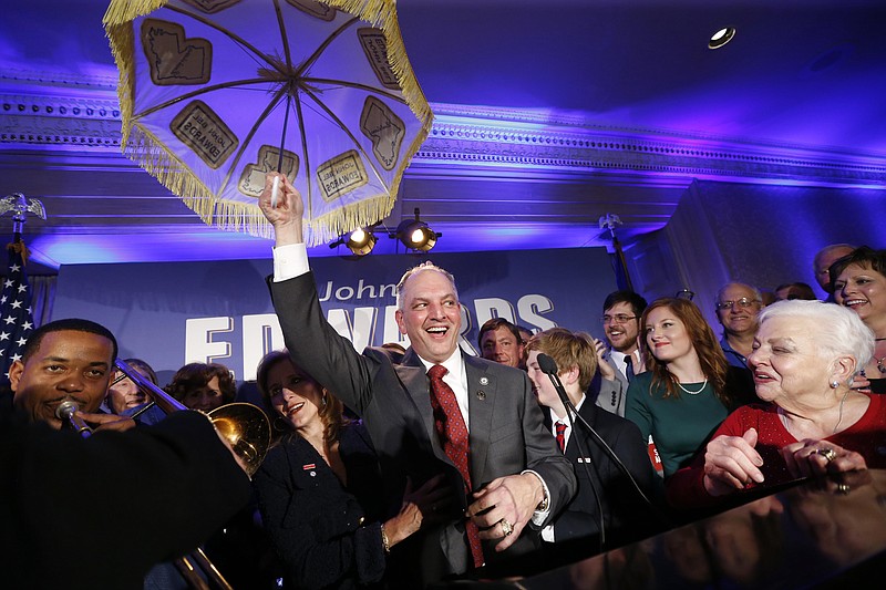 
              Louisiana Gov.-elect John Bel Edwards holds up an umbrella as he reacts with supporters at his election night watch party in New Orleans, Saturday, Nov. 21, 2015. Edwards won the runoff election for Louisiana governor Saturday, defeating the once-heavy favorite, Republican David Vitter, and handing the Democrats their first statewide victory since 2008. (AP Photo/Gerald Herbert)
            
