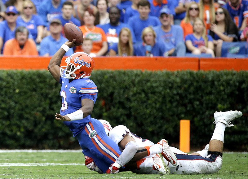 
              Florida quarterback Treon Harris (3) tires to throws a pass as he is tackled by Florida Atlantic defensive lineman Hunter Snyder, right, during the first half of an NCAA college football game, Saturday, Nov. 21, 2015, in Gainesville, Fla. Harris was ruled down on the play. (AP Photo/John Raoux)
            