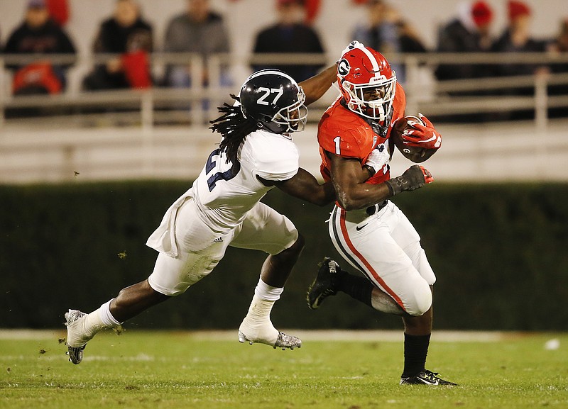 Georgia running back Sony Michel (1) is stopped by Georgia Southern linebacker Ironhead Gallon (27) in the first half of an NCAA college football game Saturday, Nov. 21, 2015, in Athens, Ga. 