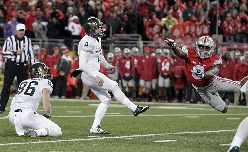 Michigan State kicker Michael Geiger, center, watches his game-winning a 41-yard field goal as Ohio State cornerback Gareon Conley, right, tries for the block as time expired in the fourth quarter of an NCAA college football game Saturday, Nov. 21, 2015, in Columbus, Ohio. Michigan State beat Ohio State 17-14.