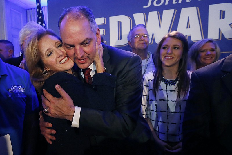 
              Louisiana Gov.-elect John Bel Edwards hugs his wife Donna Edwards as he arrives to greet supporters at his election night watch party in New Orleans, Saturday, Nov. 21, 2015. At right is his daughter Sarah Ellen Edwards. Edwards won the runoff election for Louisiana governor Saturday, defeating the once-heavy favorite, Republican David Vitter, and handing the Democrats their first statewide victory since 2008. (AP Photo/Gerald Herbert)
            