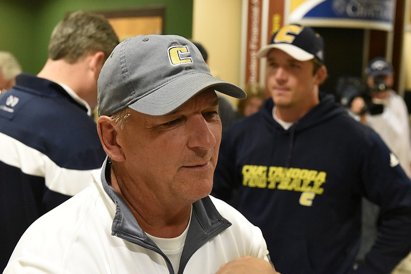 With UTC quarterback Jacob Huesman standing at right, UTC coach Russ Huesman — the QB's father — talks with a reporter after the Mocs learned Sunday they would host Fordham in the opening round of the FCS playoffs this week.
