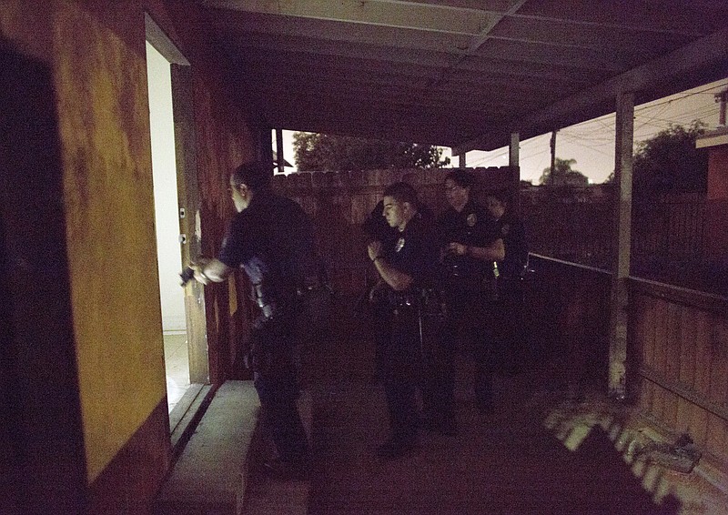 
              In this Tuesday, Oct. 27, 2015, photo, Los Angeles police officers check an unoccupied residence in South Los Angeles. In 2015, murders in Los Angeles are up 12 percent and shootings have jumped 20 percent. In response to the rising numbers, the LAPD has deployed hundreds of elite officers to crime hot spots, increased the number of officers walking the streets versus patrolling in cars, and created a community relationship division dedicated to building the public's trust in police officers. But Police Chief Charlie Beck says his department can't solve the problem alone. (AP Photo/Damian Dovarganes)
            