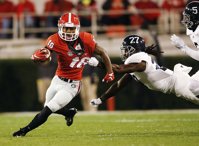 Georgia wide receiver Isaiah McKenzie (16) tries to escape from Georgia Southern linebacker Ironhead Gallon (27) in the first half of an NCAA college football game Saturday, Nov. 21, 2015, in Athens, Ga. 