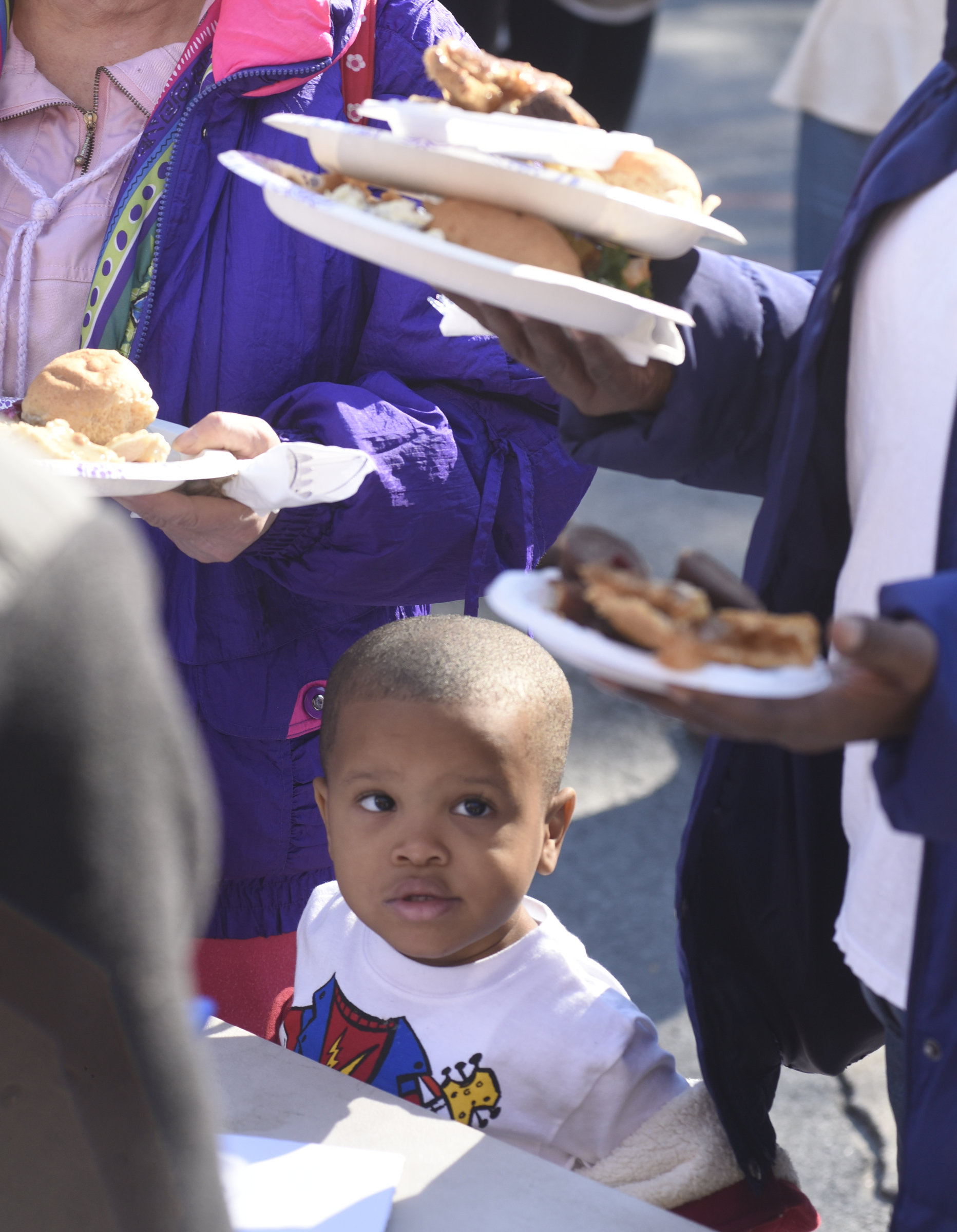 Three-year-old Kalen Pope watches as his grandmother and others pick up plates of food during the second annual One Table event Monday, Nov. 23, 2015, in Chattanooga, Tenn. The event features a Thanksgiving meal available to anyone, and is served on long table in the middle of ML King Boulevard in between Miller Park and Miller Plaza.