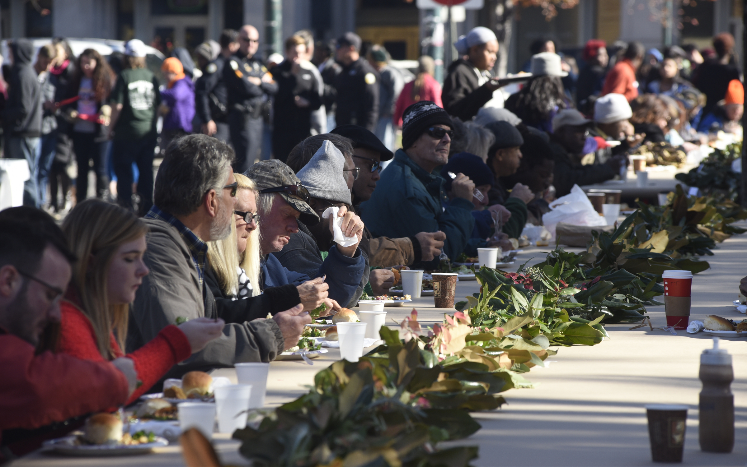 People eat during the second annual One Table event Monday, Nov. 23, 2015, in Chattanooga, Tenn. The event features a Thanksgiving meal available to anyone, and is served on long table in the middle of ML King Boulevard in between Miller Park and Miller Plaza.