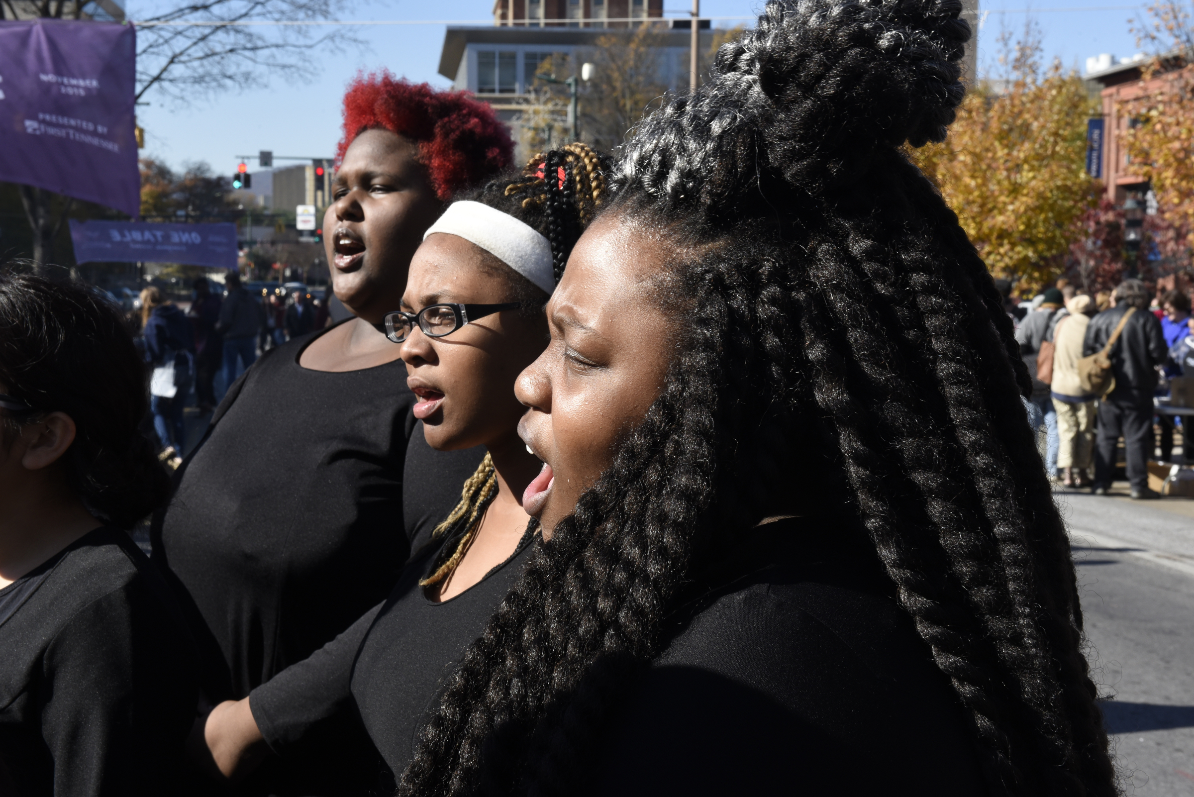 Marcayla Skillern, DeCaira Hubbard and Mai Dupress, from left, join other members of a choral group from the Chattanooga Girls Leadership Academy as they sing Christmas music during the second annual One Table event Monday, Nov. 23, 2015, in Chattanooga, Tenn.
The event features a Thanksgiving meal available to anyone, and is served on long table in the middle of ML King Boulevard in between Miller Park and Miller Plaza.