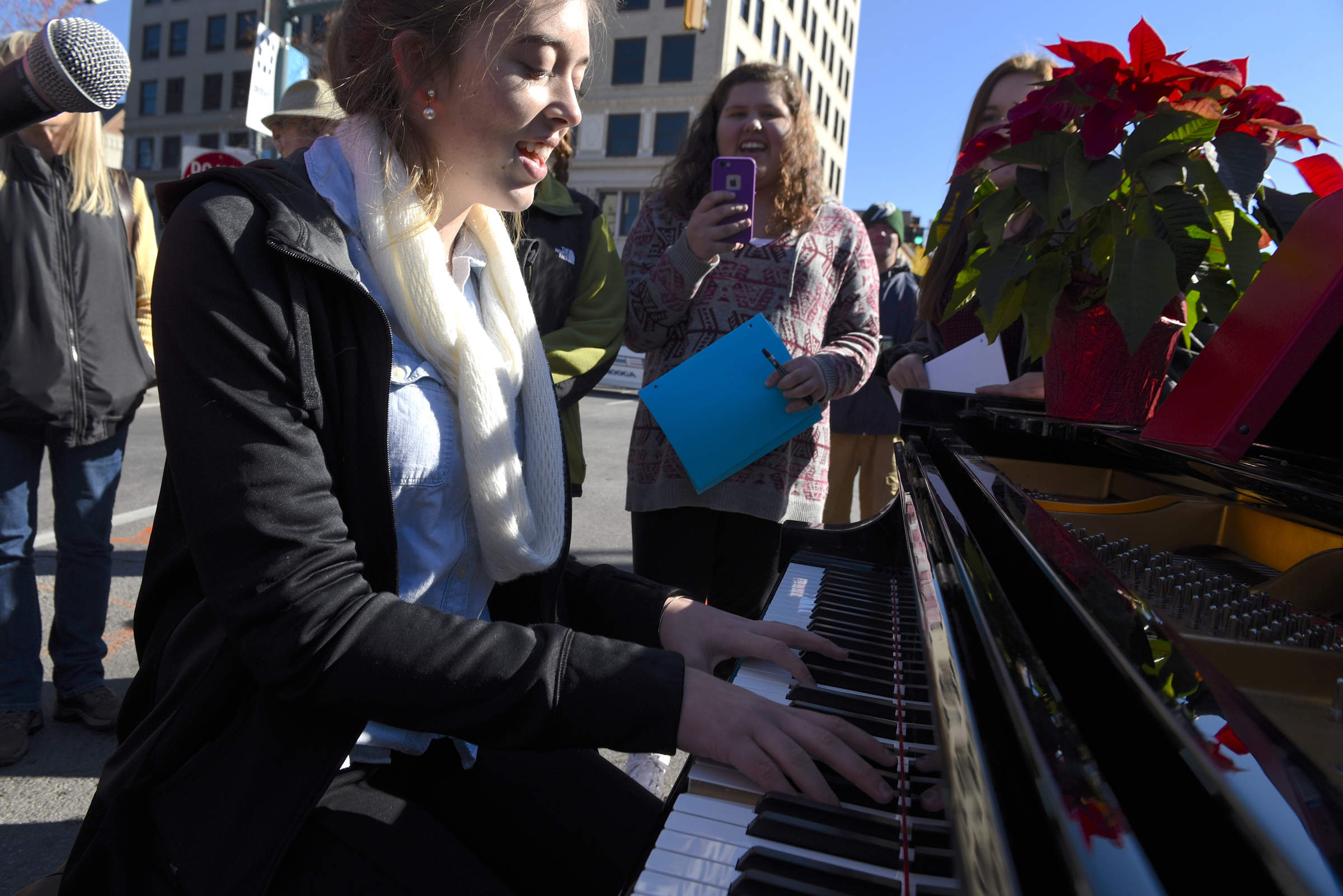 Emilee Swafford plays a Steinway grand piano while others gather around and join in to sing during the second annual One Table event in the middle of ML King Boulevard on Monday, Nov. 23, 2015, in Chattanooga, Tenn. The piano was furnished for the event by Summitt Pianos.