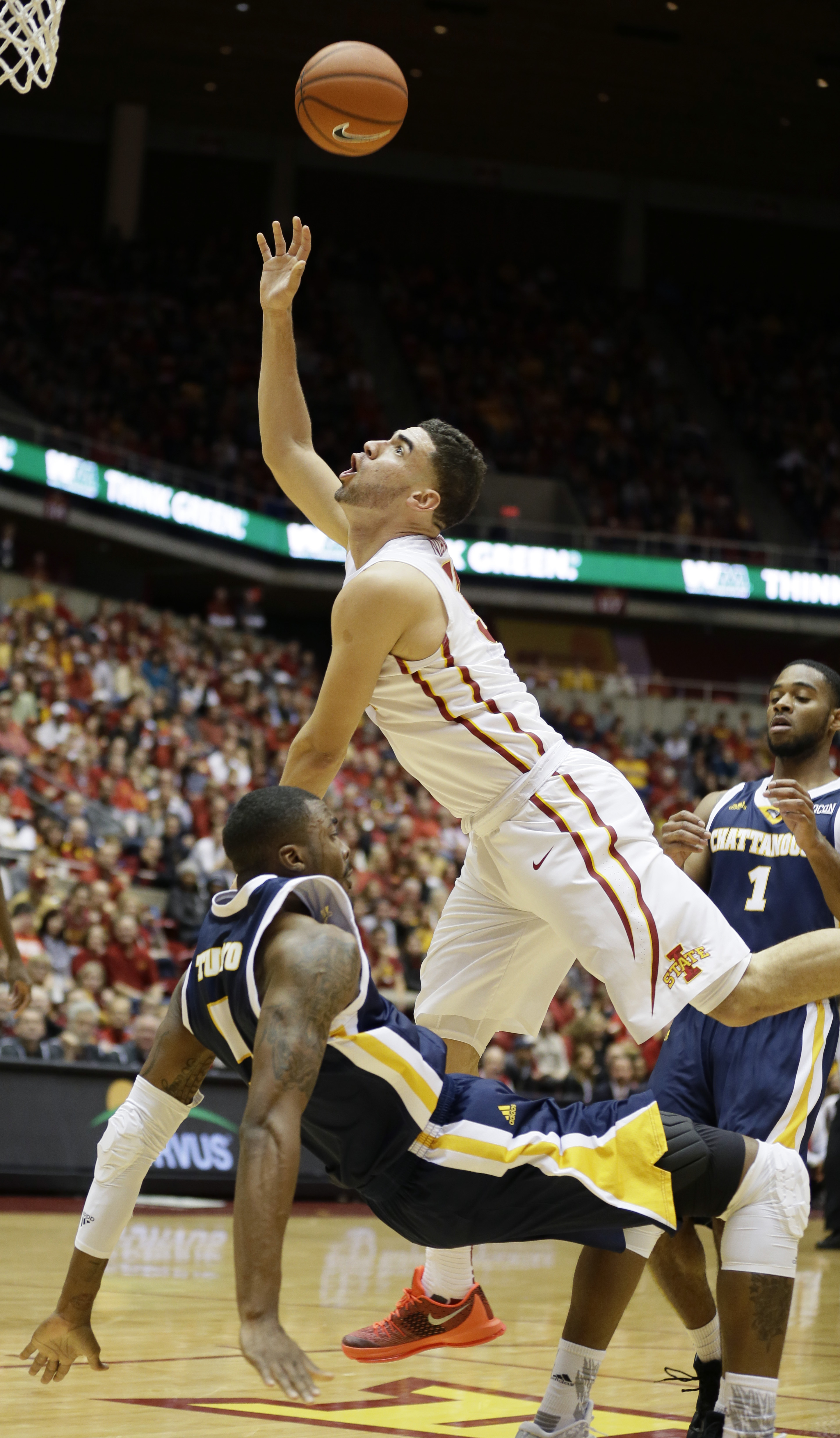 Iowa State forward Georges Niang, center, drives to the basket between Chattanooga's Justin Tuoyo, left, and Greg Pryor, right, during the first half of an NCAA college basketball game, Monday, Nov. 23, 2015, in Ames, Iowa. Niang was called for a could on the play. (AP Photo/Charlie Neibergall)