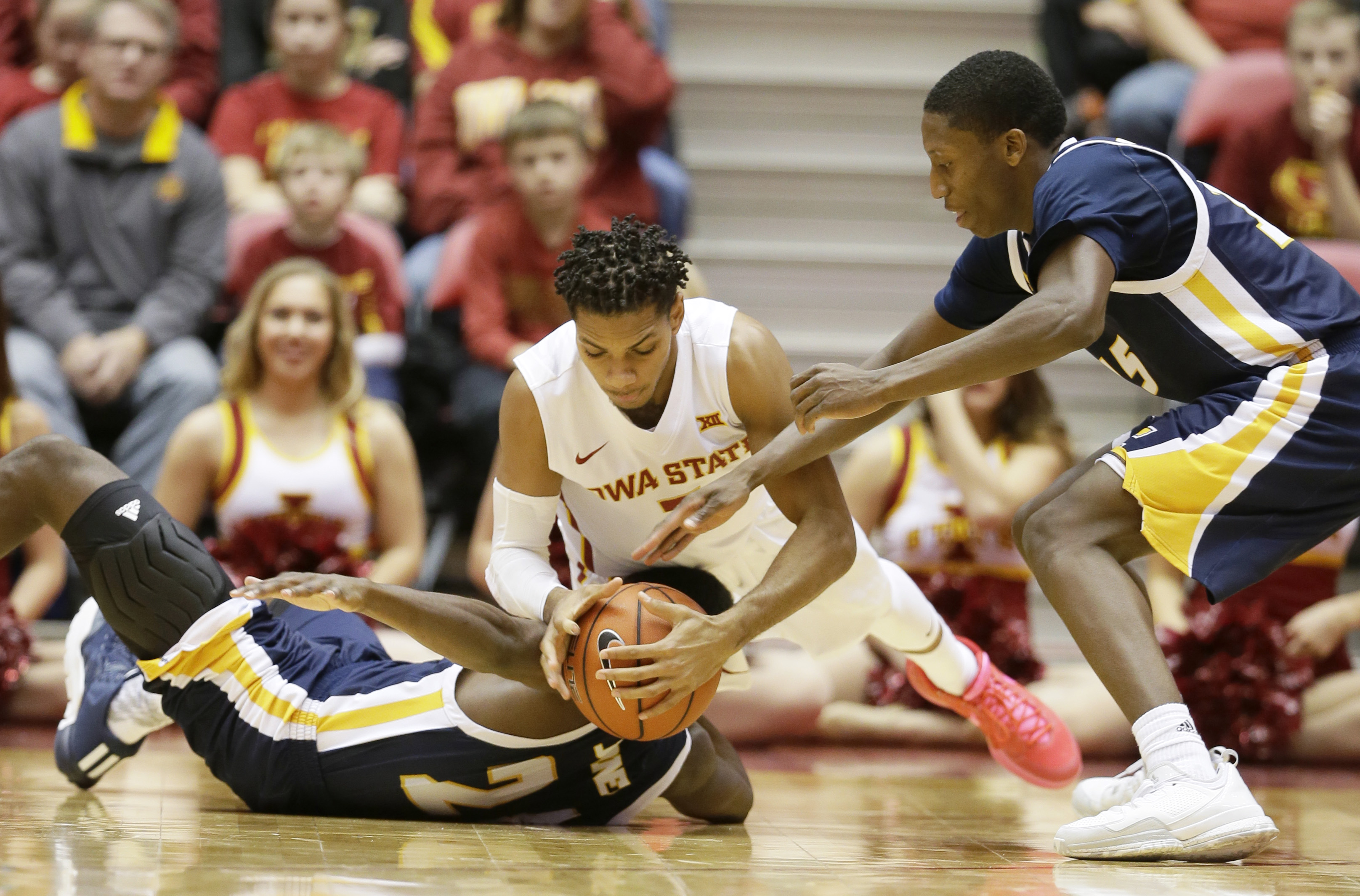 Iowa State guard Hallice Cooke, center, fights for a loose ball with Chattanooga's Casey Jones, left, and Eric Robertson, right, during the first half of an NCAA college basketball game, Monday, Nov. 23, 2015, in Ames, Iowa. (AP Photo/Charlie Neibergall)
