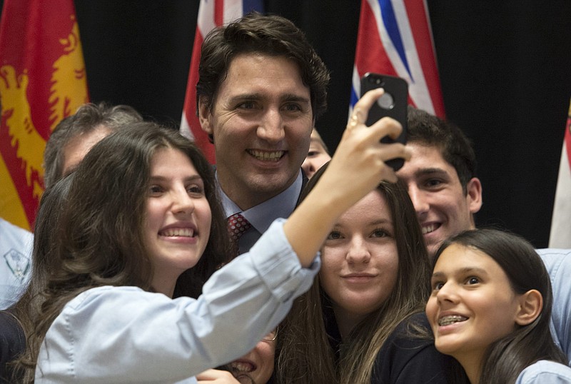 
              Canadian Prime Minister Justin Trudeau has his photo taken with students from a local school following an information session on climate change during a First Ministers meeting at the Museum of Nature on Monday, Nov. 23, 2015 in Ottawa. (Adrian Wyld/The Canadian Press via AP) MANDATORY CREDIT
            