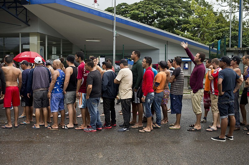 
              In this Saturday, Nov. 21, 2015 photo, Cuban migrants line up for breakfast given to them by an evangelical church, outside of the border control building in Penas Blancas, Costa Rica, on the border with Nicaragua. Thousands of Cuban migrants have been able to make the trip to the U.S. thanks to a constant flow of information between migrants starting the journey and those who have just completed it. (AP Photo/Esteban Felix)
            