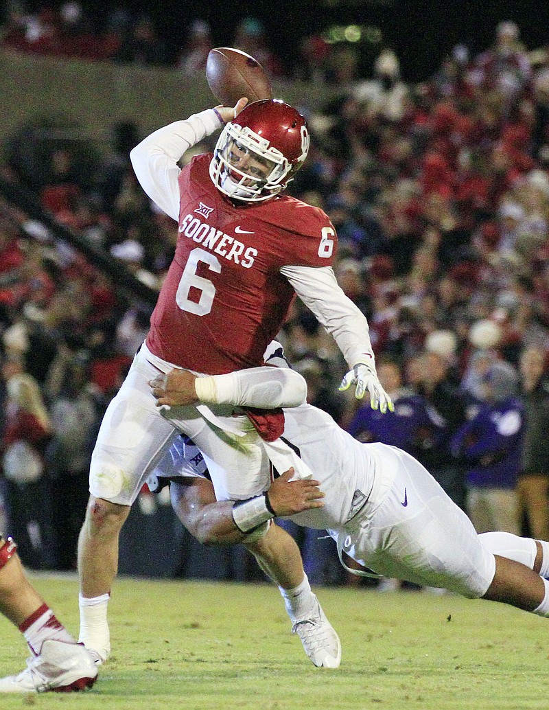 
              Oklahoma quarterback Baker Mayfield (6) is tackled by TCU defensive tackle Aaron Curry (95) as he passes during the second quarter of an NCAA college football game in Norman, Okla., Saturday, Nov. 21, 2015. (AP Photo/Alonzo Adams)
            