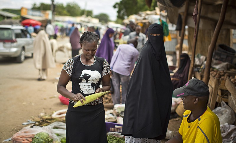 
              In this photo taken Monday, Nov. 9, 2015, a Kenyan Muslim woman wearing a niqab, right, looks across as a Kenyan Christian woman, left, buys corn at a street market in Garissa, eastern Kenya. This Kenyan town in which Islamic extremists killed nearly 150 at a college of mostly Christian students in April offers a snapshot of what France and Lebanon, both targeted in recent attacks, and other countries face - the challenge of harmonizing Christian-Muslim relations at a time of danger from extremists - an issue that Pope Francis is expected to address during his trip Nov. 25-30 to Kenya, Uganda and the Central African Republic. (AP Photo/Ben Curtis)
            