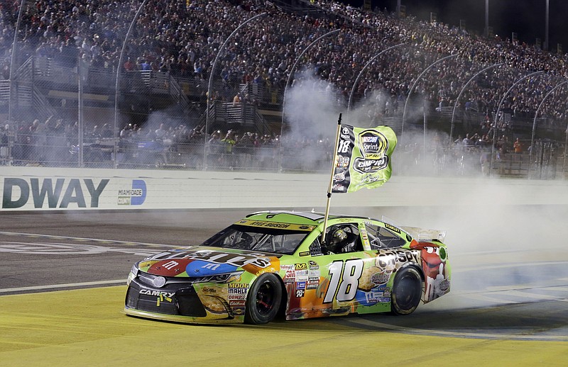 Kyle Busch celebrates after winning the NASCAR Sprint Cup Series auto race and the season title Sunday, Nov. 22, 2015, at Homestead-Miami Speedway in Homestead, Fla.