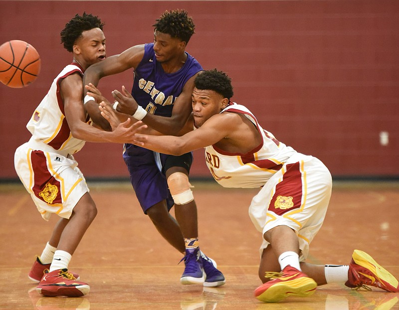 Howard's Marquez Williams, left, and Sayyid Muhammad, right, double team Central's Emmanuel Lane in a first half tussle for possession Tuesday night at Howard.