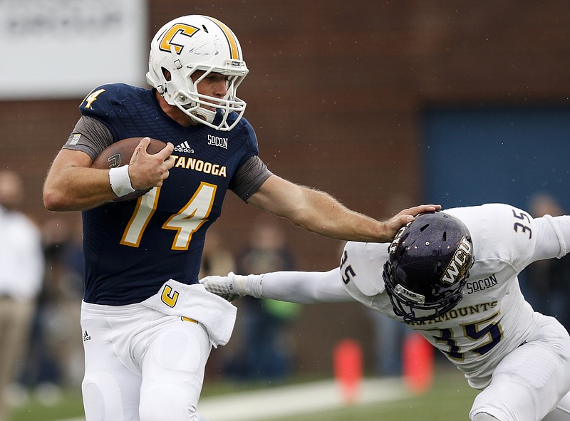 UTC quarterback Jacob Huesman stiff-arms Western Carolina defensive back Keion Crossen during the Mocs' SoCon football game against Western Carolina at Finley Stadium on Saturday, Oct. 31, 2015, in Chattanooga, Tenn.