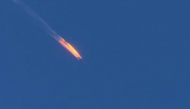 This frame grab from video by Haberturk TV, shows a Russian warplane on fire before crashing on a hill as seen from Hatay province, Turkey, Tuesday, Nov. 24, 2015.