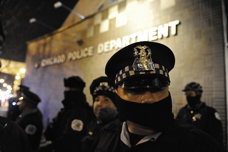 
              Chicago police officers line up outside the District 1 central headquarters at 17th and State streets, Tuesday, Nov. 24, 2015, during a protest for 17-year-old Laquan McDonald, who was fatally shot and killed in October 2014 in Chicago. Chicago police Officer Jason Van Dyke was charged Tuesday with first-degree murder in the killing. (AP Photo/Paul Beaty)
            