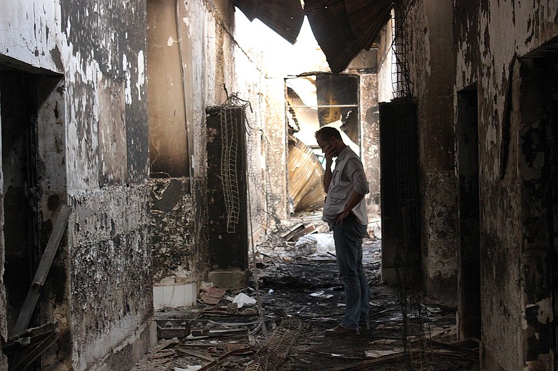 
              FILE - In this Friday, Oct. 16, 2015, file photo, an employee of Doctors Without Borders walks inside the charred remains of their hospital after it was hit by a U.S. airstrike in Kunduz, Afghanistan. An investigative report on the U.S. air attack that killed more than two dozen civilians at a medical charity's hospital in northern Afghanistan last month says the crew of the attacking plane misidentified the target, believing it to be a government compound taken over by the Taliban.  (Najim Rahim via AP)
            